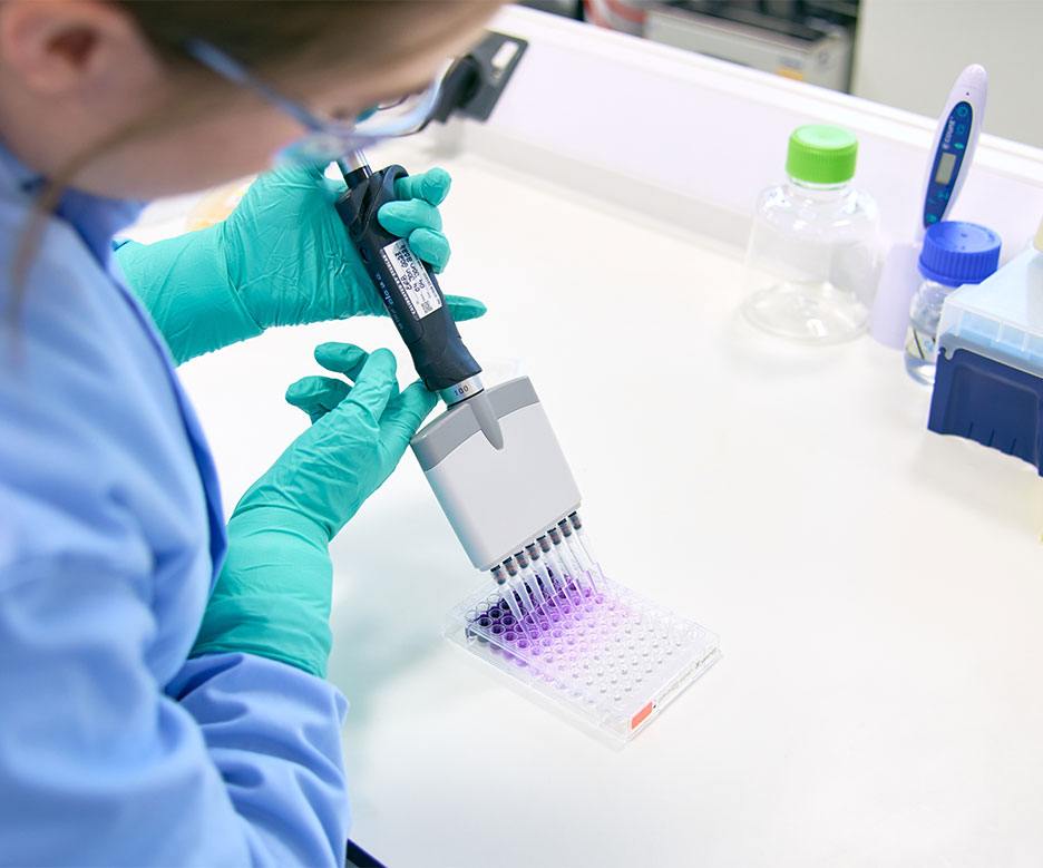 Researcher depositing liquid into test tube