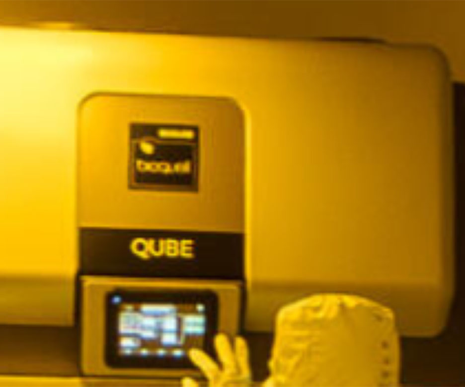 People working in the yellow cleanroom containing the Bioquell Grade A Isolator Qube.