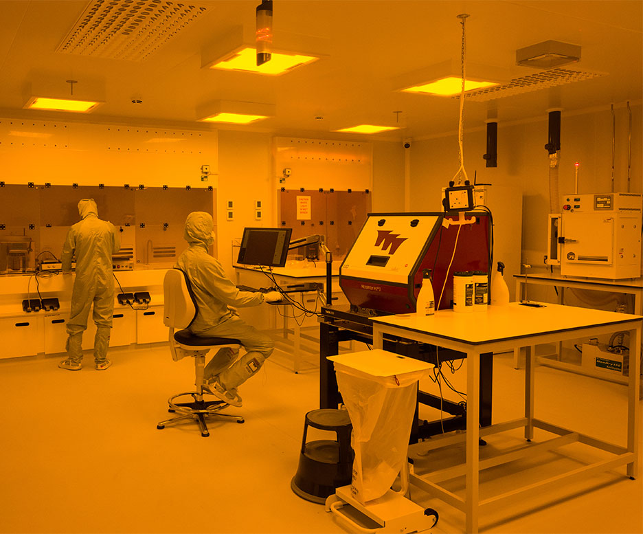 Technicians in the yellow cleanroom.